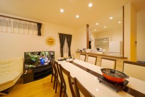 a living room with a television and a table with chairs at Maple House - Vacation STAY 85725 in Fukuoka
