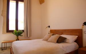 Un dormitorio con una cama con sábanas blancas y una ventana. en Tenuta Buia, en Squinzano