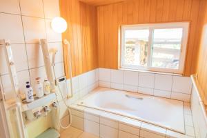 a bathroom with a tub and a window at Relaxing Log Cabin IZU HOUSE- Vacation STAY 85769 in Ito +29 photos