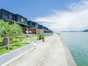 einen Weg neben einem Wasserkörper mit Häusern in der Unterkunft Rakuten STAY HOUSE Amakusa 102 in Kami Amakusa