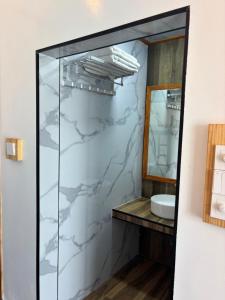 a bathroom with a glass shower with a sink at Luk inn at huraa in Huraa +12 photos