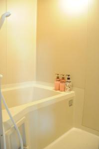 a white bathroom with a tub and a mirror at Ark City Asahikawa - Vacation STAY 8508 in Asahikawa