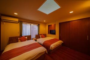 a hotel room with two beds and a skylight at Yufuin Yuki-an - Vacation STAY 86832 in Yufuin