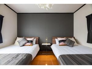 two beds sitting next to each other in a room at Hana Azusa - Vacation STAY 86863 in Yufuin