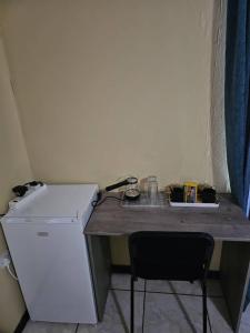 a small kitchen with a counter and a refrigerator at Warona Guesthome & Spa in Gaborone