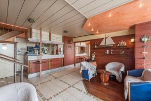 a living room with wood paneling and a kitchen at Logis Hotels - Au Poisson d'Argent - Hôtel 3 étoiles et restaurant in Le Mesnil-en-Vallée