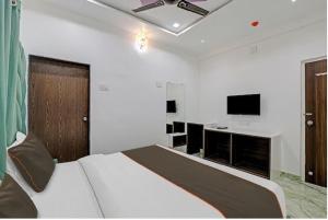 Un dormitorio con una cama y un televisor de pantalla plana. en Hotel the stay lions, en Ahmedabad