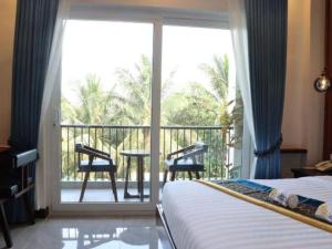 a bedroom with a bed and a balcony with a table and chairs at Sky Boutique Kampot in Phumĭ Bœ̆ng Phlŏng (2)