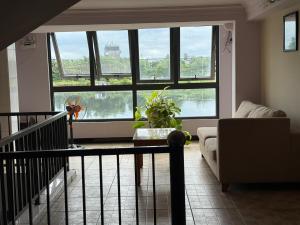 ein Wohnzimmer mit großen Fenstern und einem Sofa in der Unterkunft Bờ Sông Hotel in Ho-Chi-Minh-Stadt