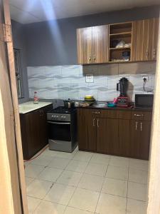 a kitchen with wooden cabinets and a stove at Sarah homes in Isheri-Olofin