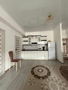 a kitchen with a refrigerator and a chair in a room at Париж in Chok-Tal