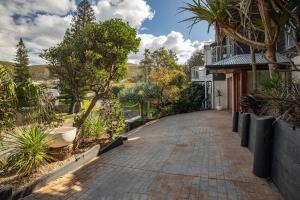 a brick driveway leading to a house with trees at Headlands At Blueys in Blueys Beach