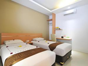 a room with two beds and a laptop in it at Guest House Nozz in Semarang