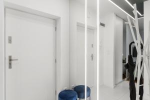 vestidor con sillas azules y espejo en Lumina apartments next to Rondo ONZ, en Varsovia