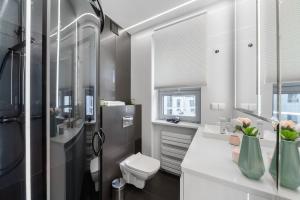 un baño con inodoro y lavabo en Lumina apartments next to Rondo ONZ, en Varsovia