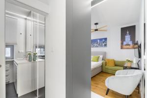 Sala de estar blanca con sofá y silla en Lumina apartments next to Rondo ONZ, en Varsovia