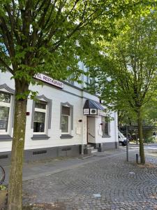 a white building on the side of a street at Stadt-Gut-Hotel Zum Rathaus in Oberhausen
