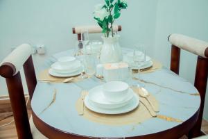 a table with plates and glasses and a vase at Stand-alone- 2BR house in Dodoma in Dodoma