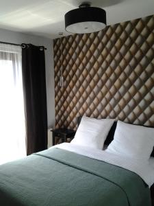 une chambre avec un grand lit avec une grande tête de lit dans l'établissement Garden Corner, à Cracovie