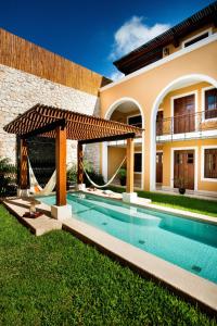 a swimming pool in front of a house at Boutique by The Museo in Mérida