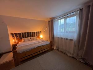 En eller flere senge i et værelse på Ciumarna Holiday House