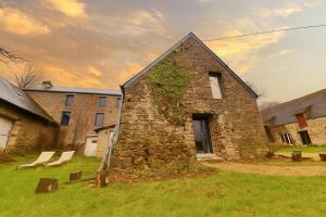 an old stone building with ivy growing on it at Ferme 16 pers Calme et Nature à Clécy in Clécy