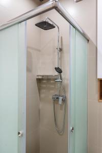 a shower with a glass door in a bathroom at Светлая квартира-студия в 5-минутах от Мега Парк in Almaty
