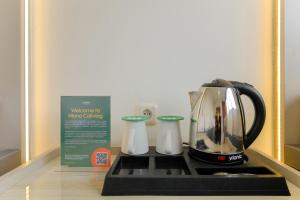 a black and white tea kettle on a counter with a box at Mono Coliving Kota Tua, Jakarta in Jakarta
