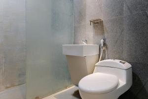 a bathroom with a white toilet and a sink at Mono Coliving Kota Tua, Jakarta in Jakarta