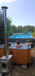 a group of people swimming in a hot tub at Osada Blanka Leśny Zakątek Jezioro Rzeka Swornegacie in Swornegacie 