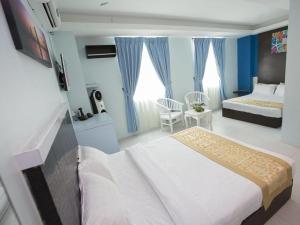 une chambre d'hôtel avec un lit et une chambre dans l'établissement Skyview Hotel, à Kampong Geliga