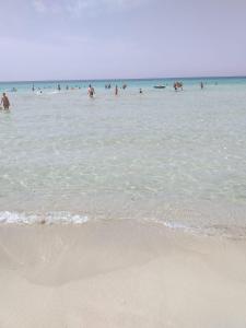 a group of people in the water at the beach at CASA VACANZA Torre Lapillo PREMIUM in Torre Lapillo +1 photo