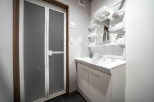 a white bathroom with a sink and a shower at Mks 201 in Asahikawa