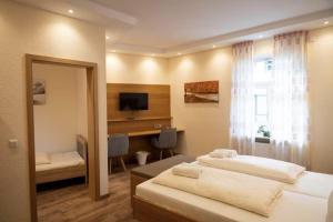 a bedroom with two beds and a desk and a window at Gasthause Zur Krone Hotel in Leimen