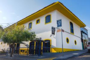 a white and yellow building with a yellow roof at Hotel do Baú in Santa Rosa de Viterbo