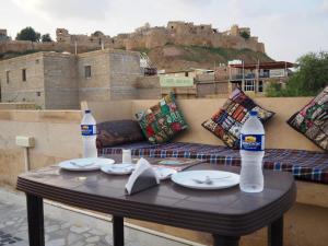 a table with two bottles of water on top of a couch at Guesthouse Tofu- Fort View in Jaisalmer