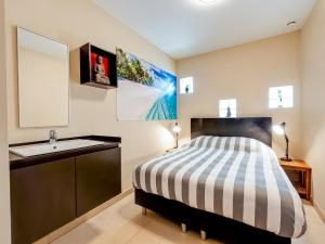 a bedroom with a bed with a sink and a mirror at Peaceful Getaway with Spa in Avelgem