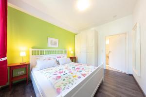 a bedroom with a bed and a green wall at Ferienwohnungen Wildblume in Winsen Aller