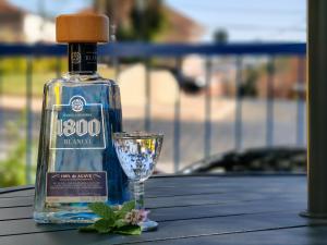 a bottle of gin next to a glass on a table at Hotel do Baú in Santa Rosa de Viterbo