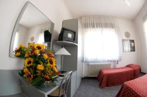 una stanza con tavolo e vaso di girasoli di Hotel Milano a Pistoia