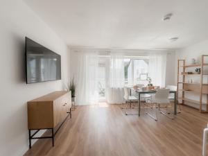 a living room with a table and a dining room at Skyrise Apartments - Zentral mit Küche, Balkon und Parkplatz in Bad Wörishofen