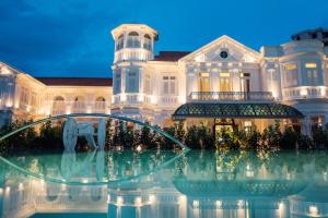 a large white mansion with a fountain in front of it at Macalister Mansion, a Member of Design Hotels in George Town