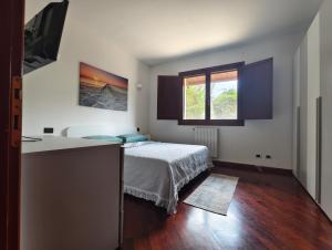a small bedroom with a bed and a window at Villetta del Sole in La Maddalena