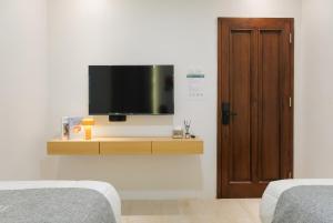 a room with two beds and a flat screen tv at Mono Coliving Kota Tua, Jakarta in Jakarta +51 photos