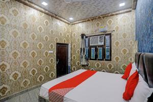 a bedroom with a bed in a room with wallpaper at Hotel O New Jagrani palace in Kānpur