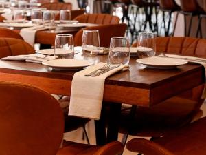 a wooden table with wine glasses and napkins on it at The Cookbook Gastro Boutique Hotel & SPA in Calpe