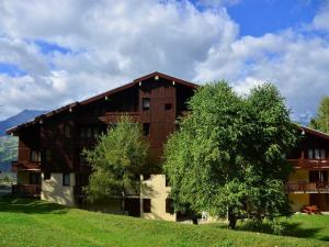 a large building with a tree in front of it at Studio rénové 3 étoiles, 4/5 pers, proche pistes, balcon, parking - FR-1-329-19 in Bellentre