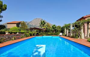 Una piscina azul con una montaña al fondo en Villa Romeijn, en Cerda