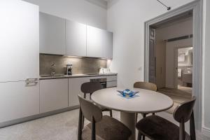 a kitchen with a table and chairs in a room at Old Theatre Suites - Panarea in Valletta
