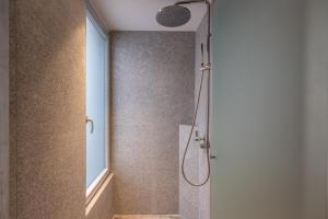 a bathroom with a shower with a glass door at Old Theatre Suites - Panarea in Valletta +5 photos